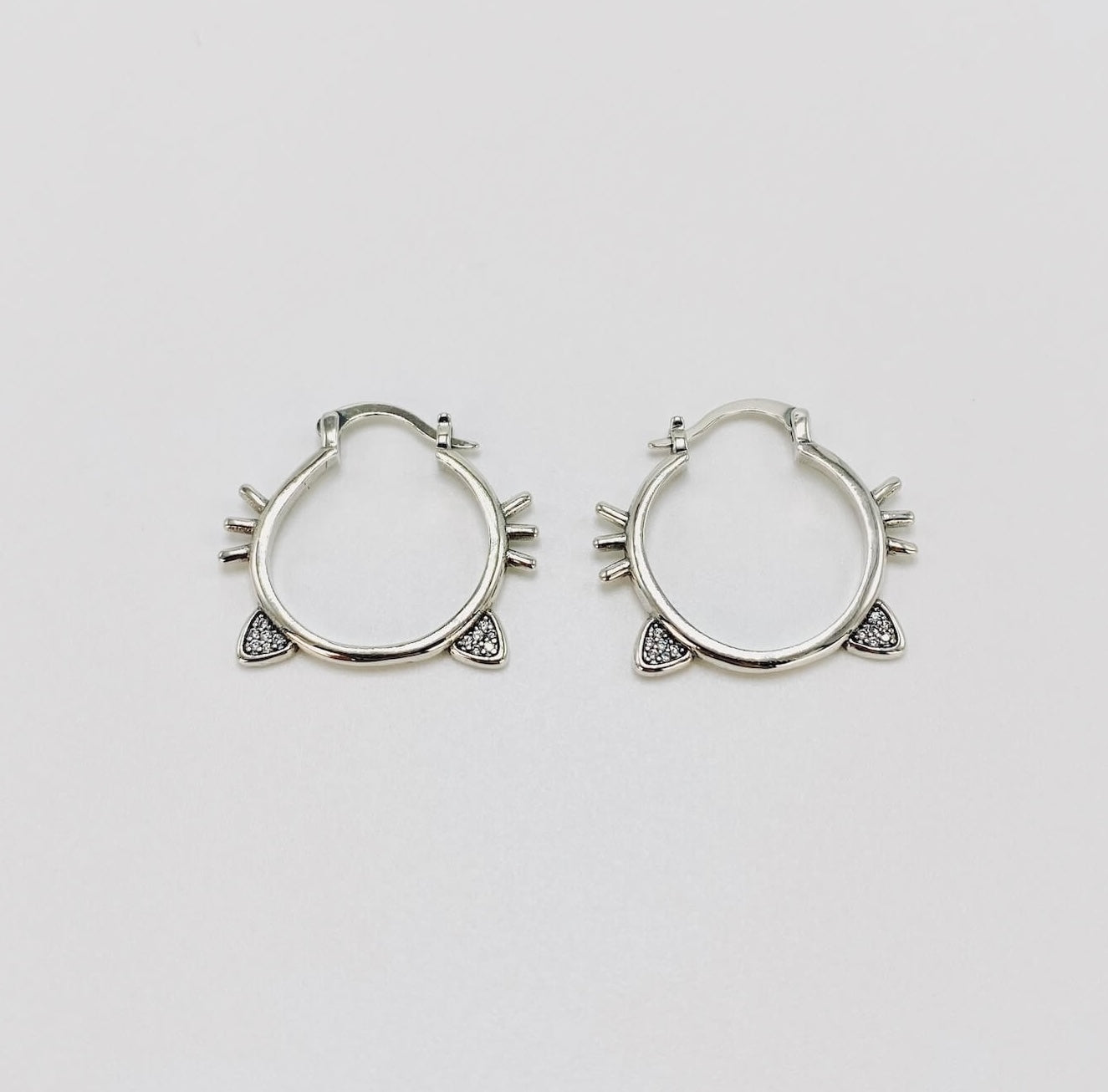 Sterling silver hoop earrings with cat ears and whiskers.