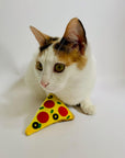 Cat playing with refillable pizza catnip toy.