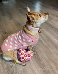 Dog posing with pink heart donut squeaker toy.