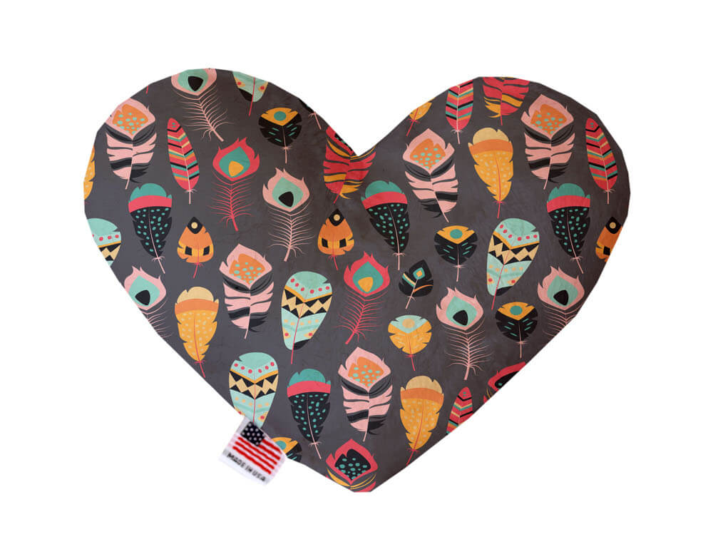 Heart shaped squeaker dog toy. Gray background with multicolored feathers printed throughout. Made in USA label on bottom trim.