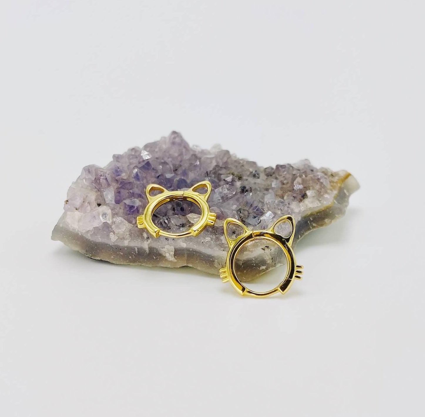 Sterling silver cat head hoop earrings in gold.