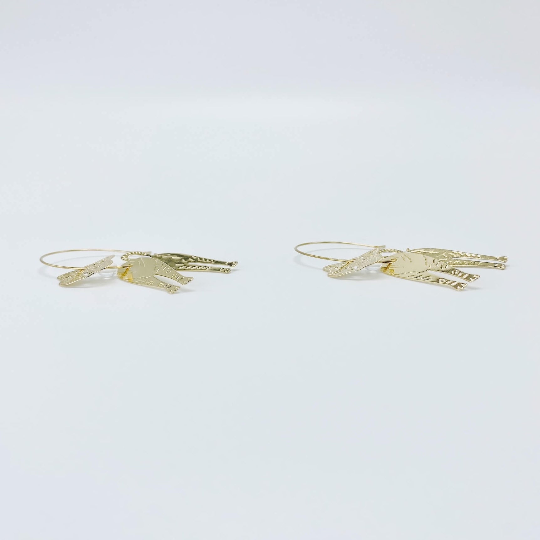 Metallic rose gold cat hoop earrings.