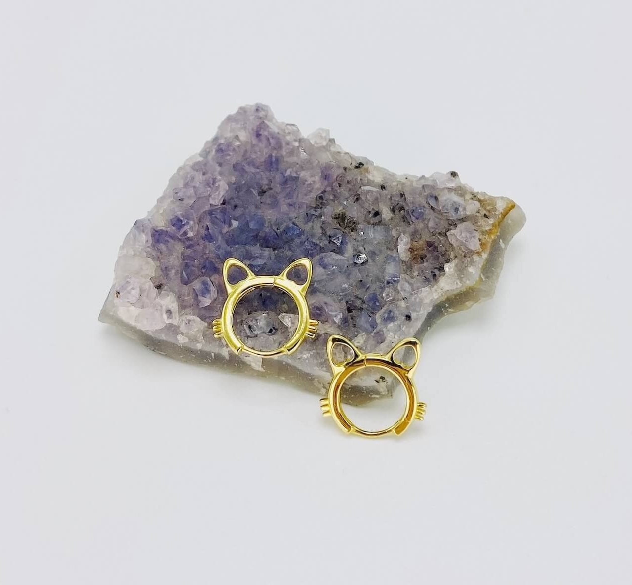 Sterling silver cat head hoop earrings in gold.