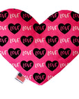 Heart shaped squeaker dog toy. Pink background with black hearts and "Love" text printed throughout. Made in USA label on bottom trim.