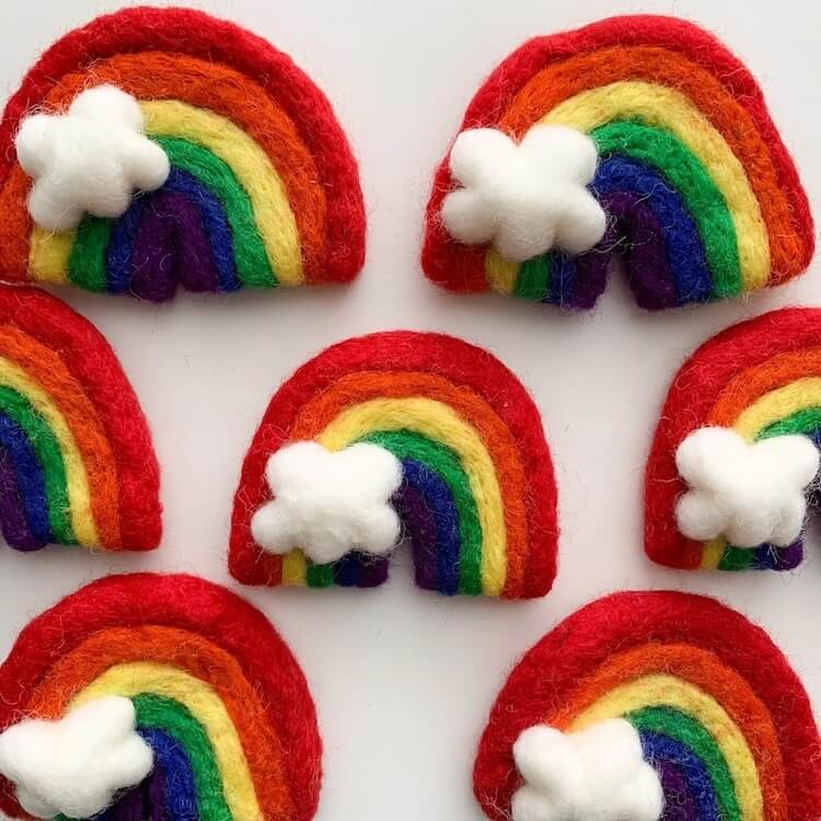 Rainbow wool cat toys with white cloud accents.