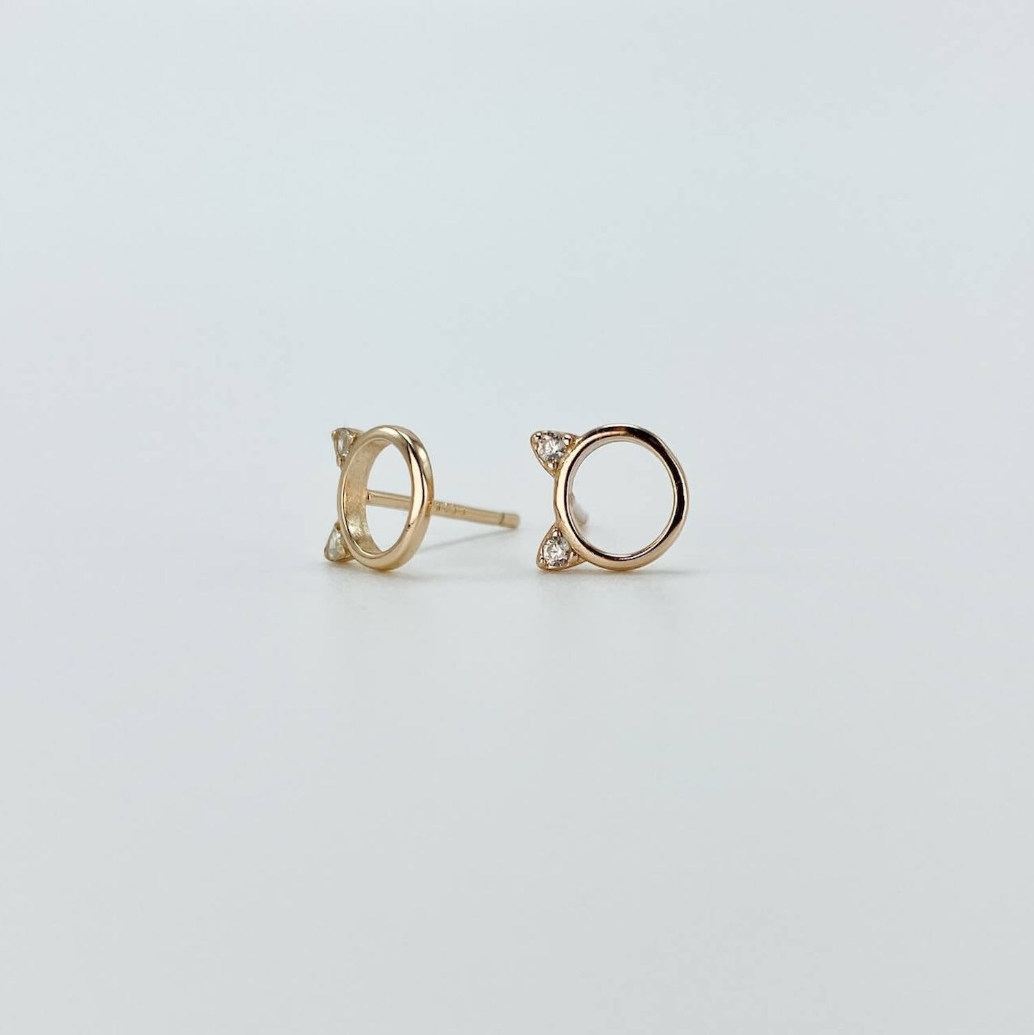 Sterling silver minimalist cat head "o" stud earrings with cubic zirconia gems in rose gold.