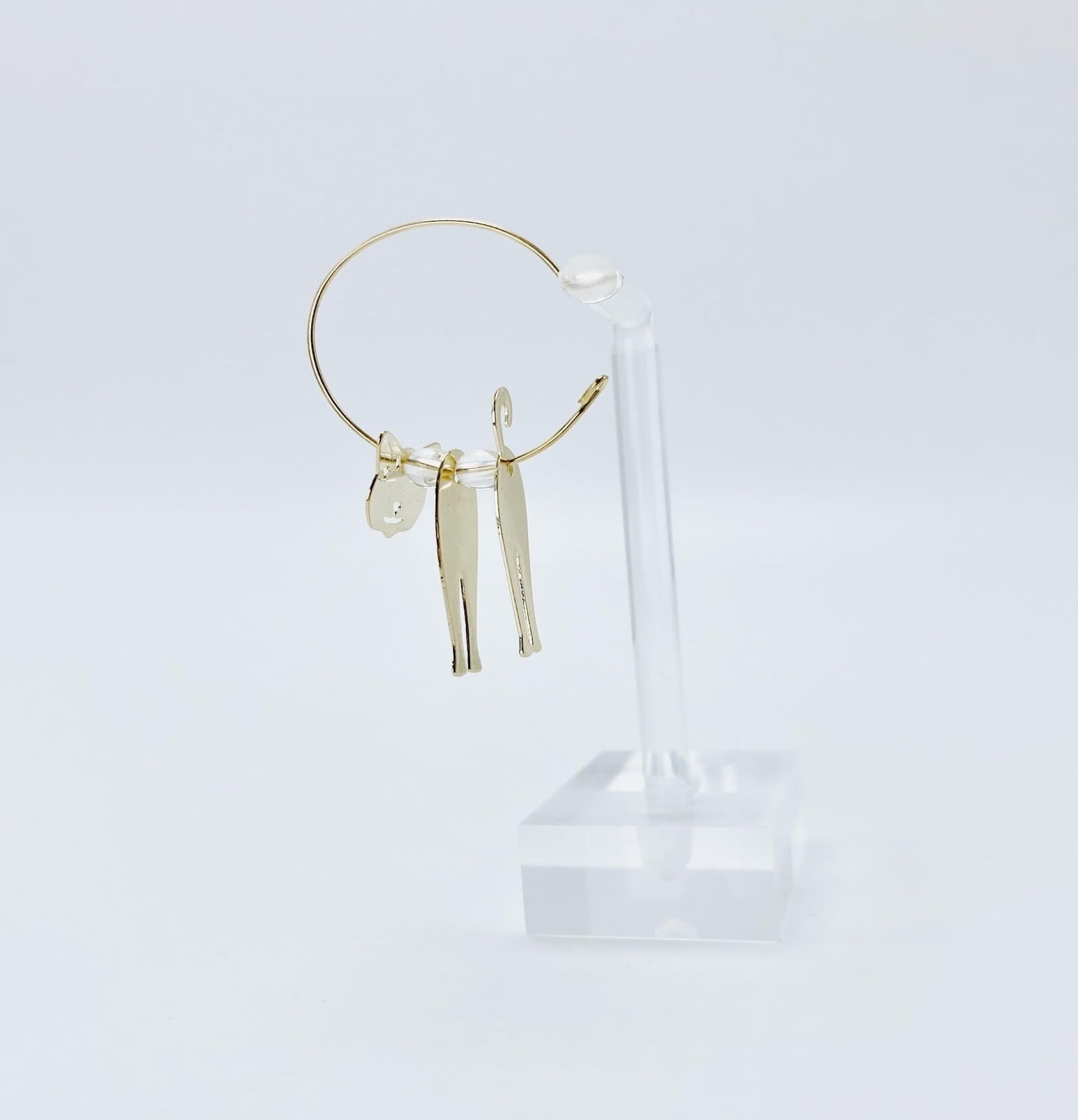 Metallic rose gold cat hoop earrings.