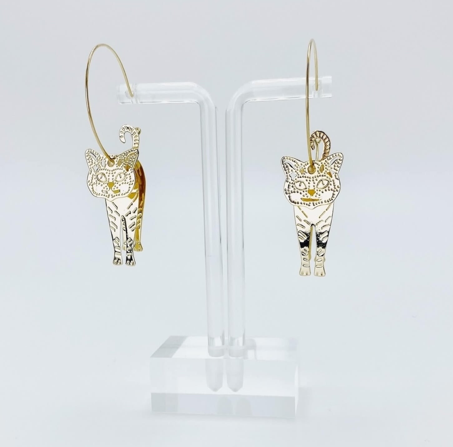 Metallic rose gold cat hoop earrings.