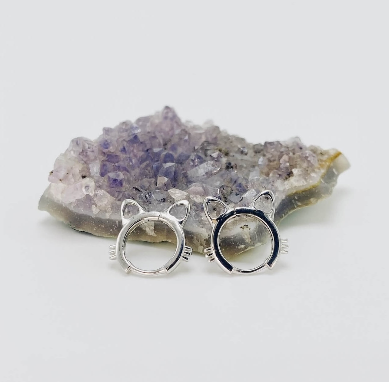 Sterling silver cat head hoop earrings in silver.