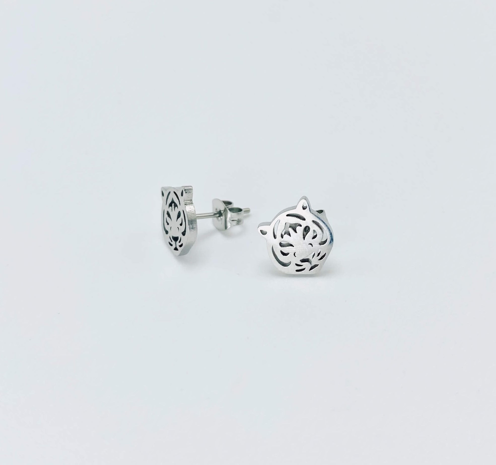 Metallic tiger stud earrings in a silver hue made from stainless steel.