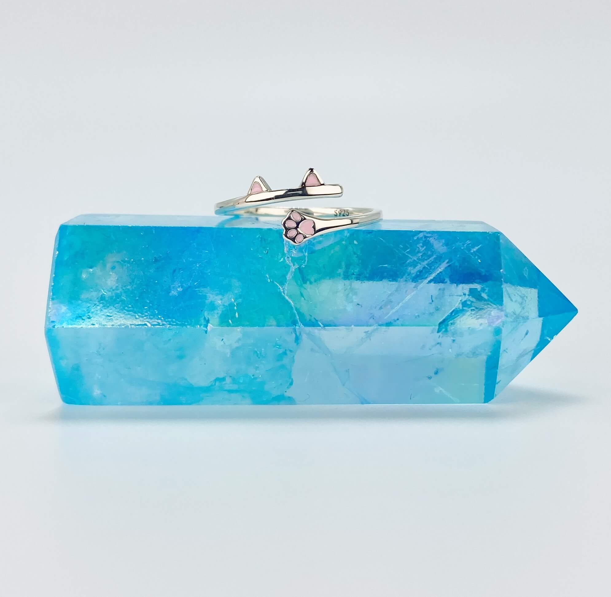 Sterling silver cat ear and paw wrap around ring sitting on blue stone.