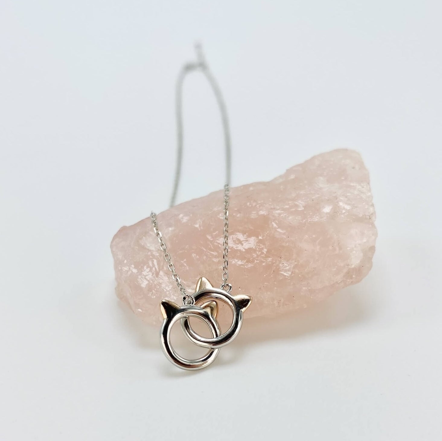 Sterling silver cat infinity necklace. Features two cat head charms that are linked.