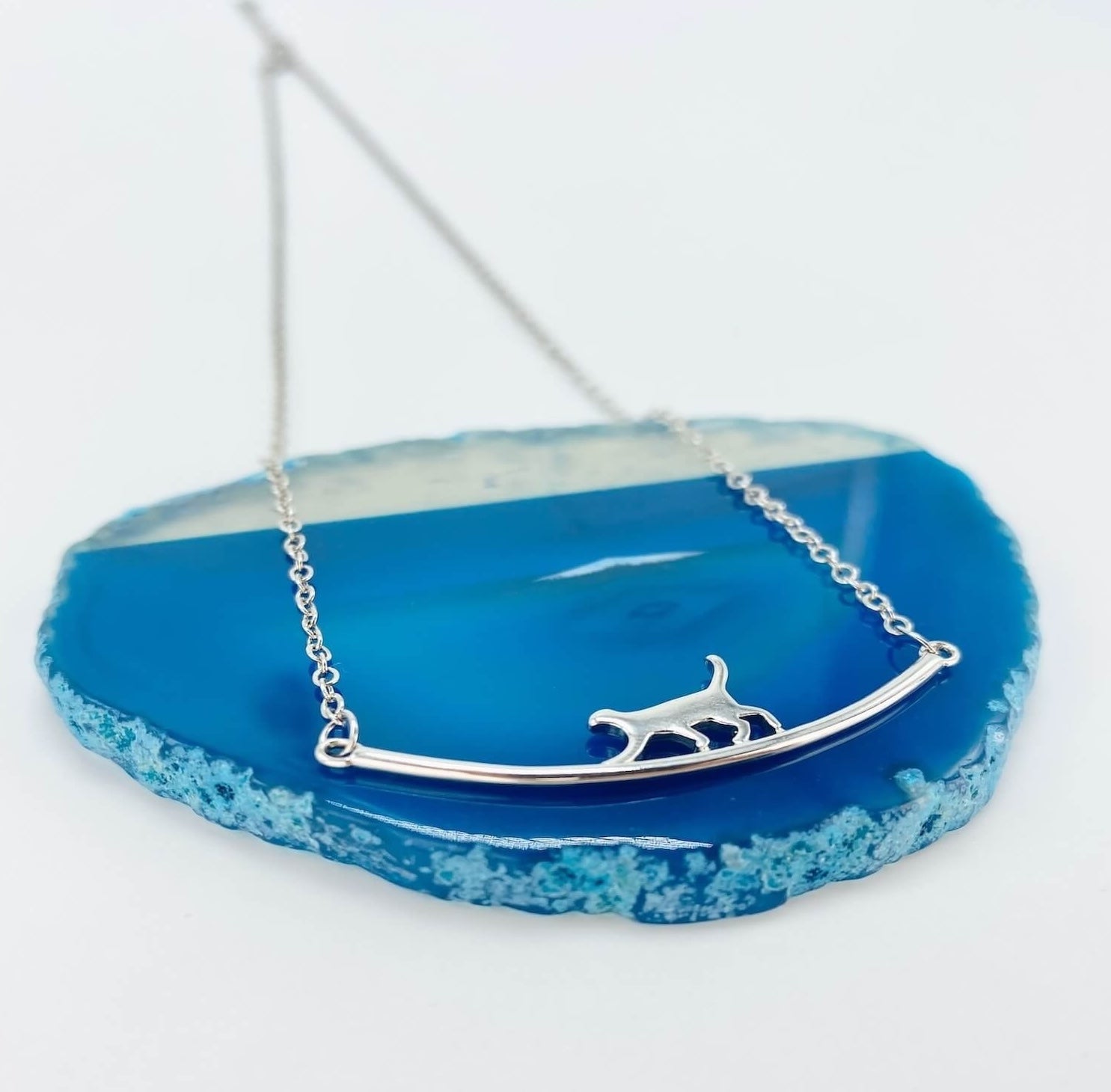 Sterling silver cat walking on bar necklace.