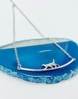 Sterling silver cat walking on bar necklace.