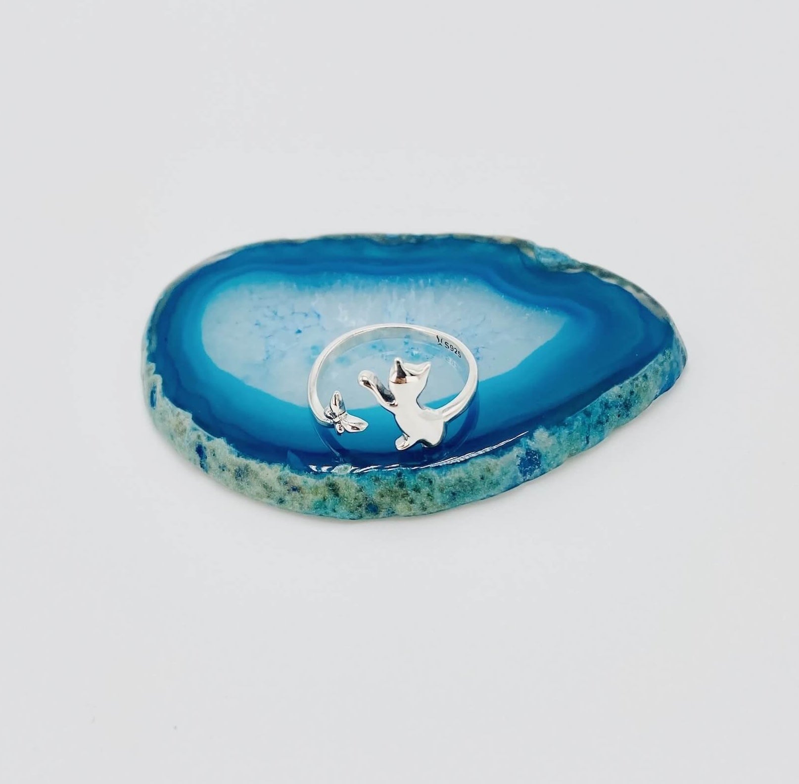 Sterling silver ring that features a cat chasing a butterfly.