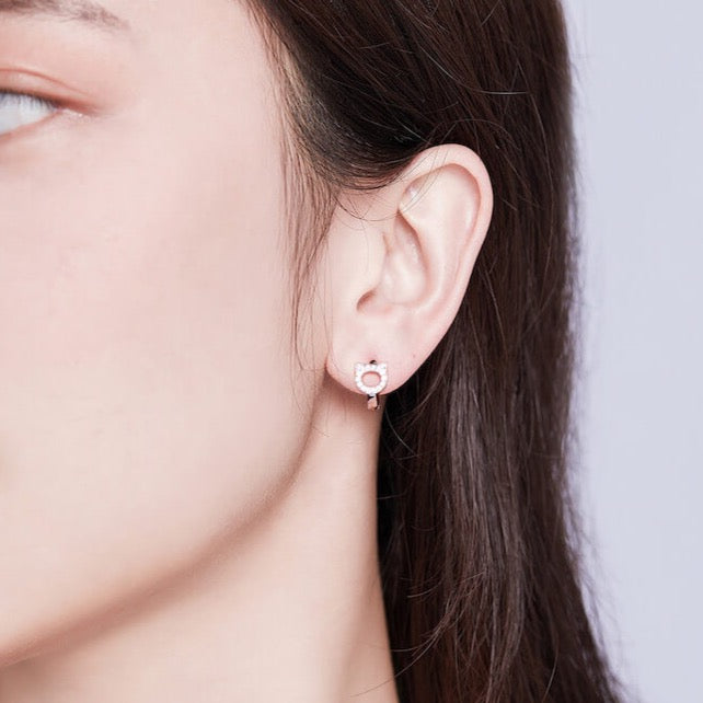Sterling silver cubic zirconia cat huggie earrings (worn by model).