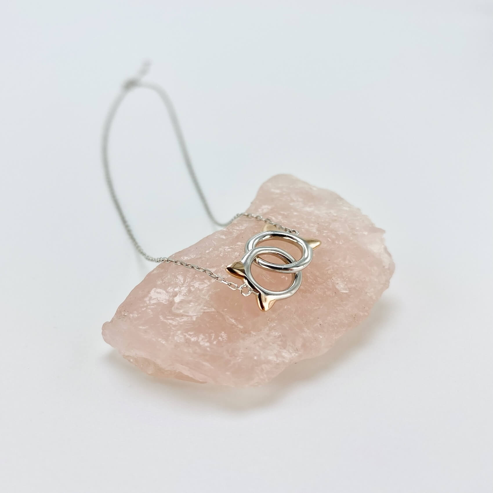 Sterling silver cat infinity necklace. Features two cat head charms that are linked.