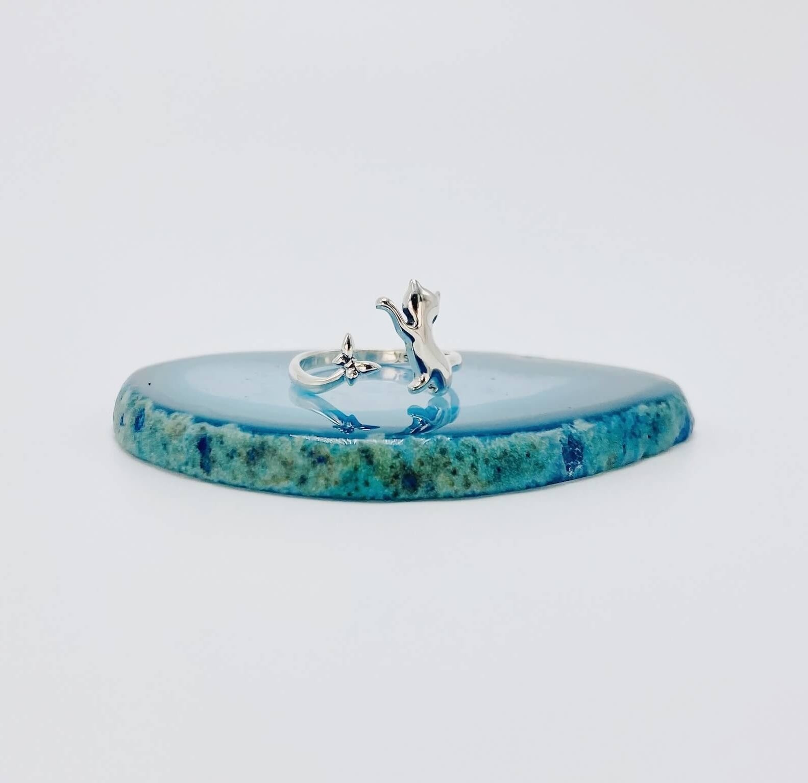 Sterling silver ring that features a cat chasing a butterfly.
