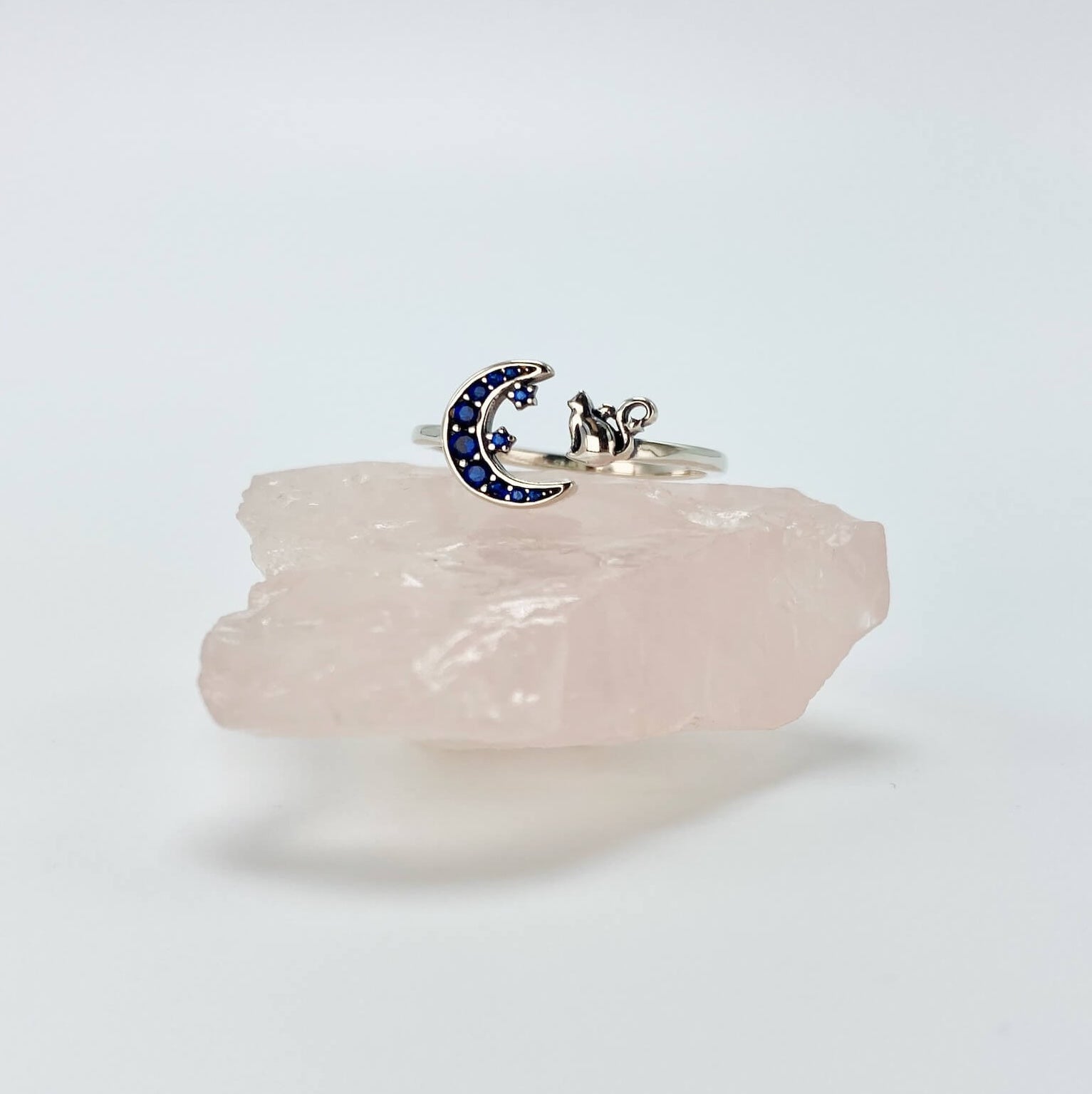 Sterling silver cat and moon ring with blue cubic zirconia gemstones in a pave setting.