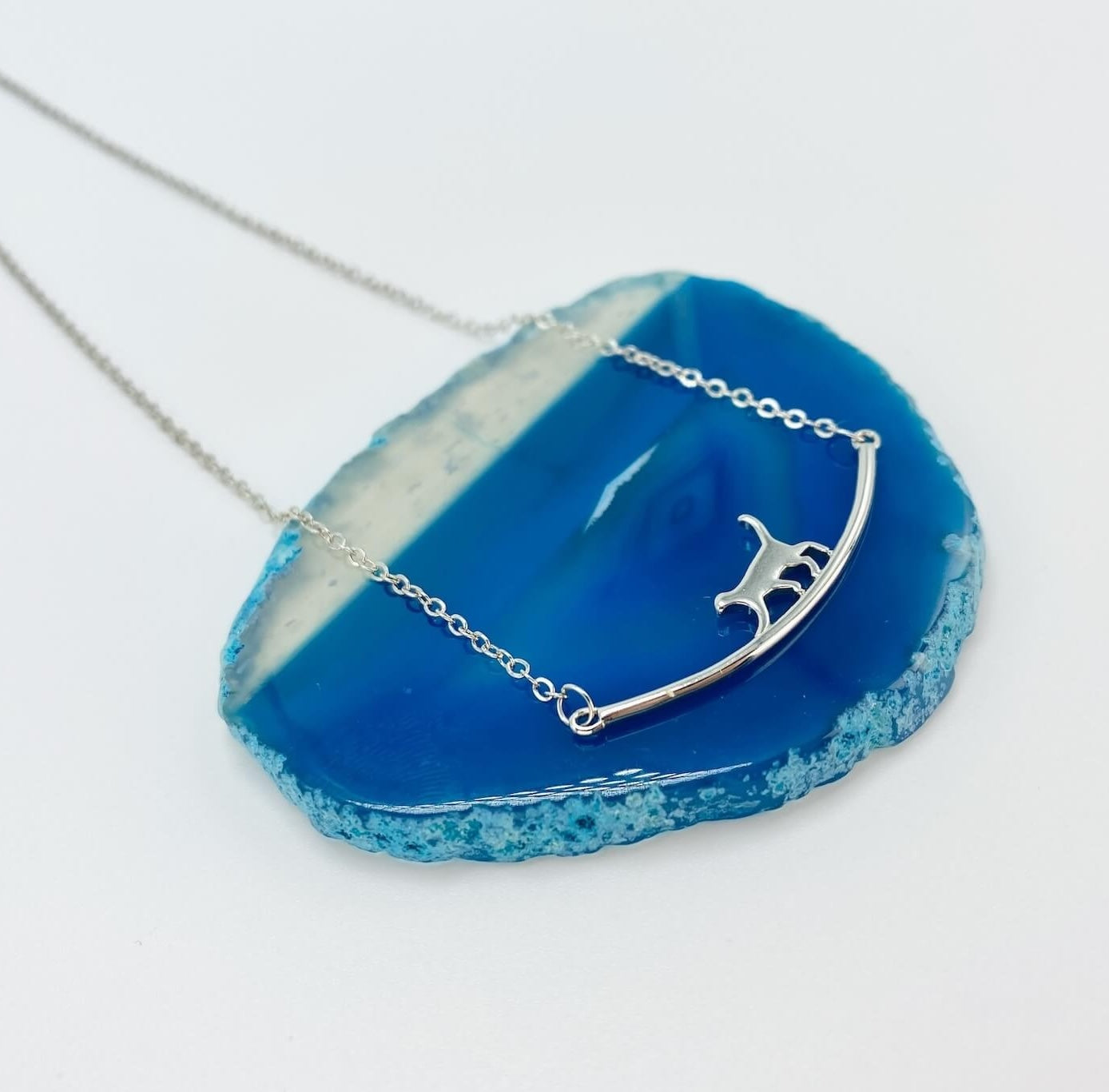 Sterling silver cat walking on bar necklace.
