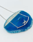 Sterling silver cat walking on bar necklace.