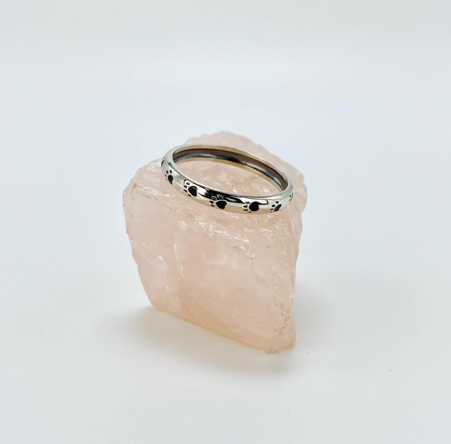 Sterling silver band ring with black enameled paw prints.