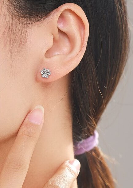 Sterling silver paw earring studs with cubic zirconia gemstones (worn by model).