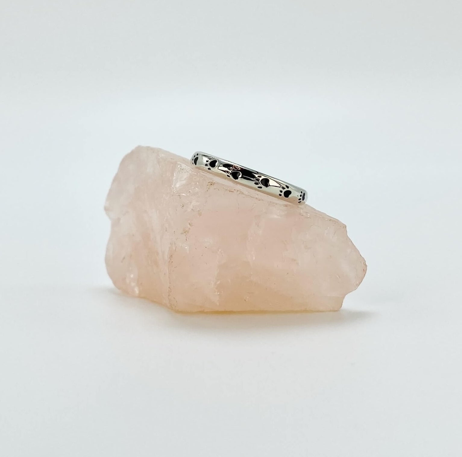 Sterling silver band ring with black enameled paw prints.
