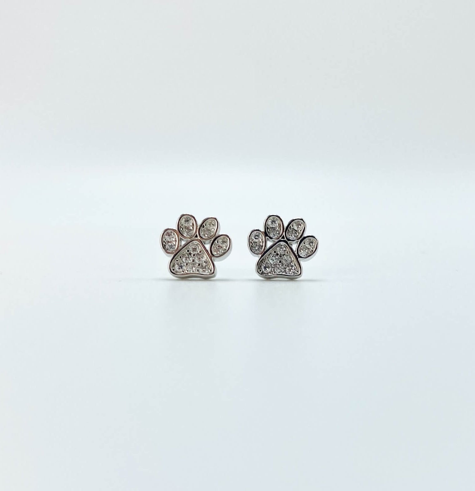 Sterling silver paw earring studs with cubic zirconia gemstones.