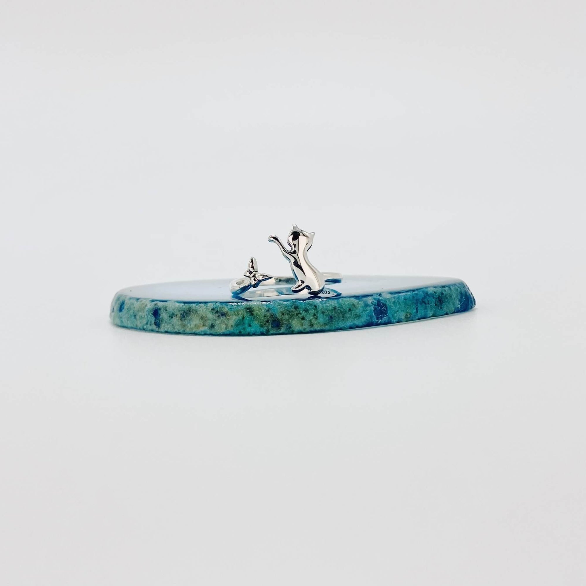 Sterling silver ring that features a cat chasing a butterfly.