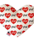 Heart shaped squeaker dog toy. White background with red hearts and "Love" text printed throughout. Made in USA label on bottom trim.