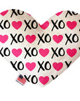 Heart shaped squeaker dog toy. White background with pink hearts and black "XO" text printed throughout. Made in USA label on bottom trim.