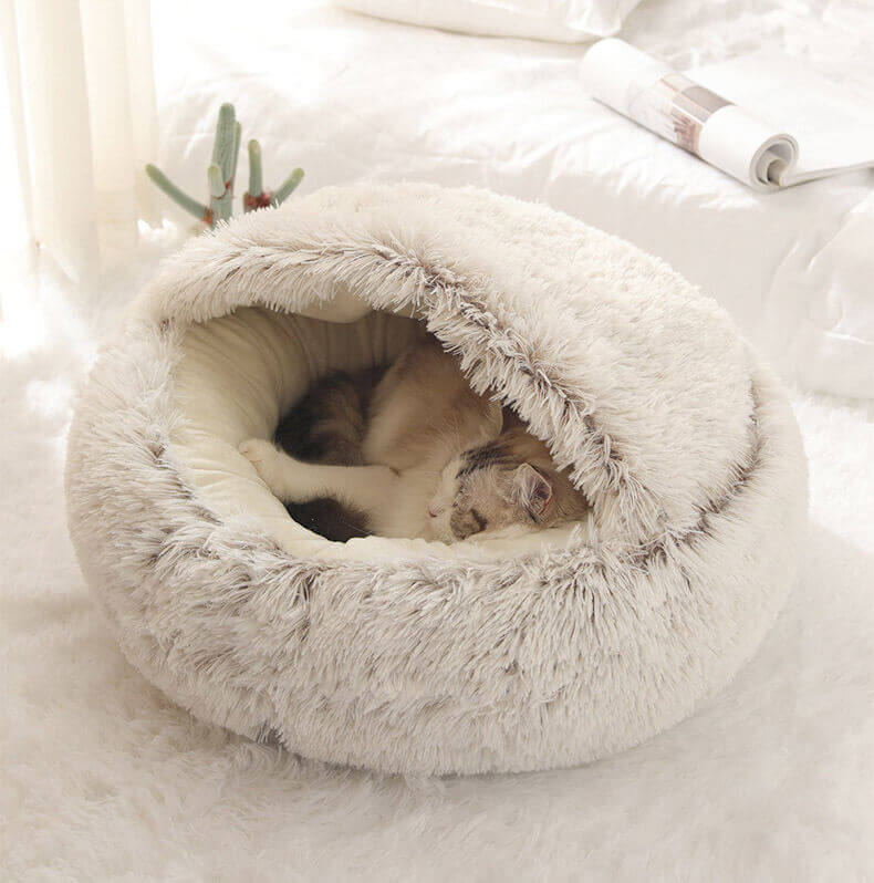 Cat resting in a light brown plush nesting cave bed (long plush version).