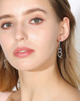 Cat and fishbone rhinestone drop earrings worn by model.