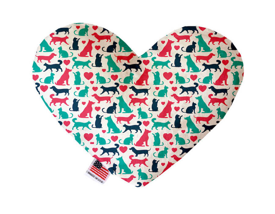 Heart shaped squeaker dog toy. White background with navy blue, seafoam green and hot pink cats, dogs, and hearts printed throughout. Made in USA label on bottom trim.
