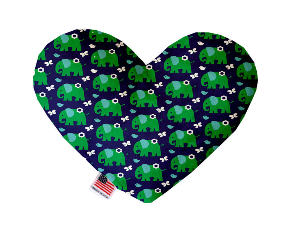 Heart shaped squeaker dog toy. Navy blue background with green elephants, and white flowers and butterflies printed throughout. Made in USA label on bottom trim.