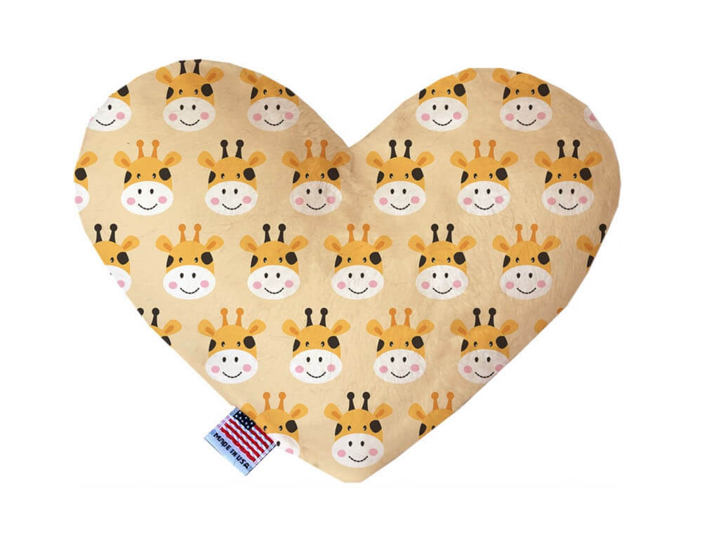 Heart shaped squeaker dog toy. Tan background with smiling giraffes printed throughout. Made in USA label on bottom trim.
