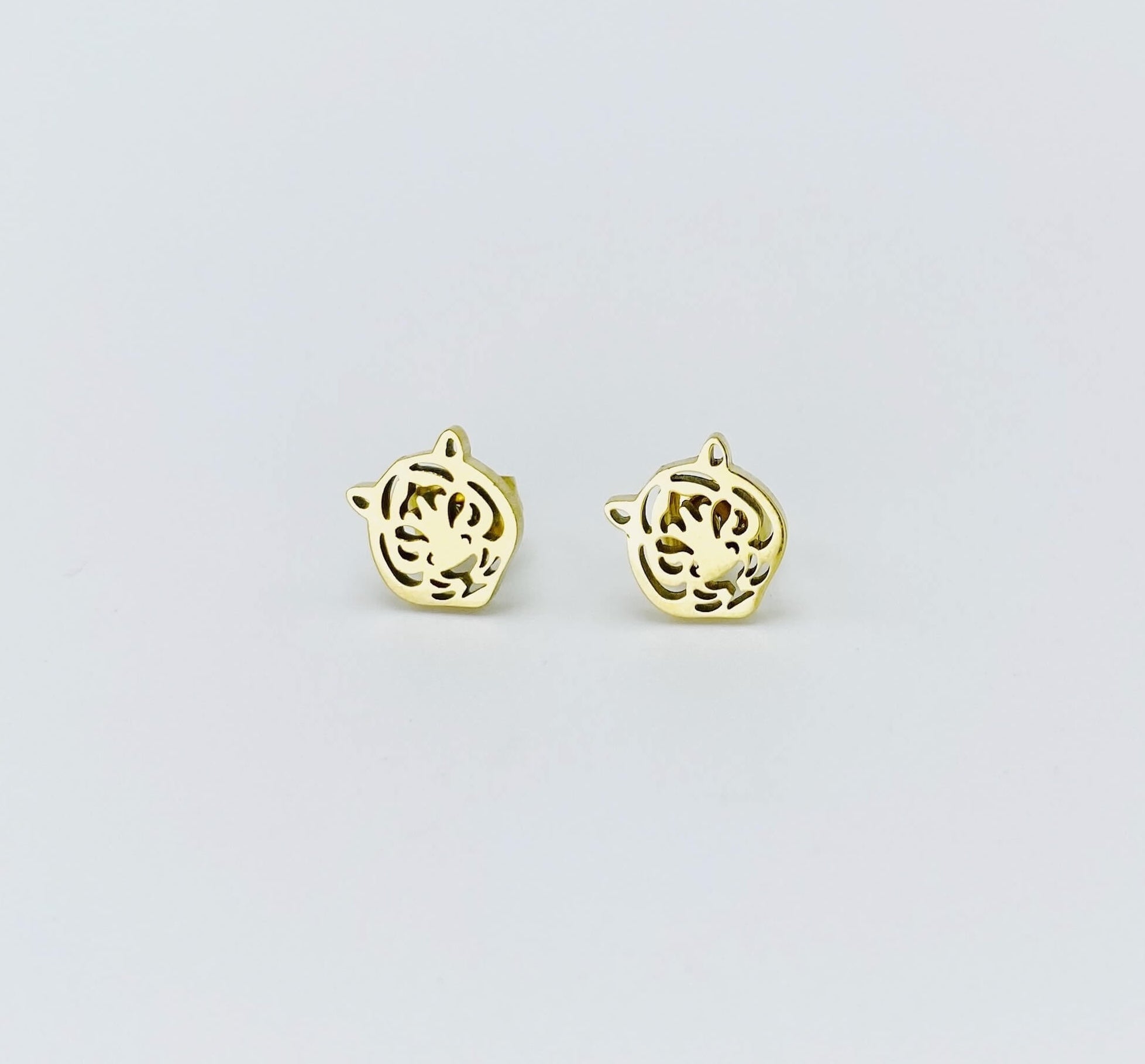 Metallic tiger stud earrings in a yellow gold hue made from stainless steel. 