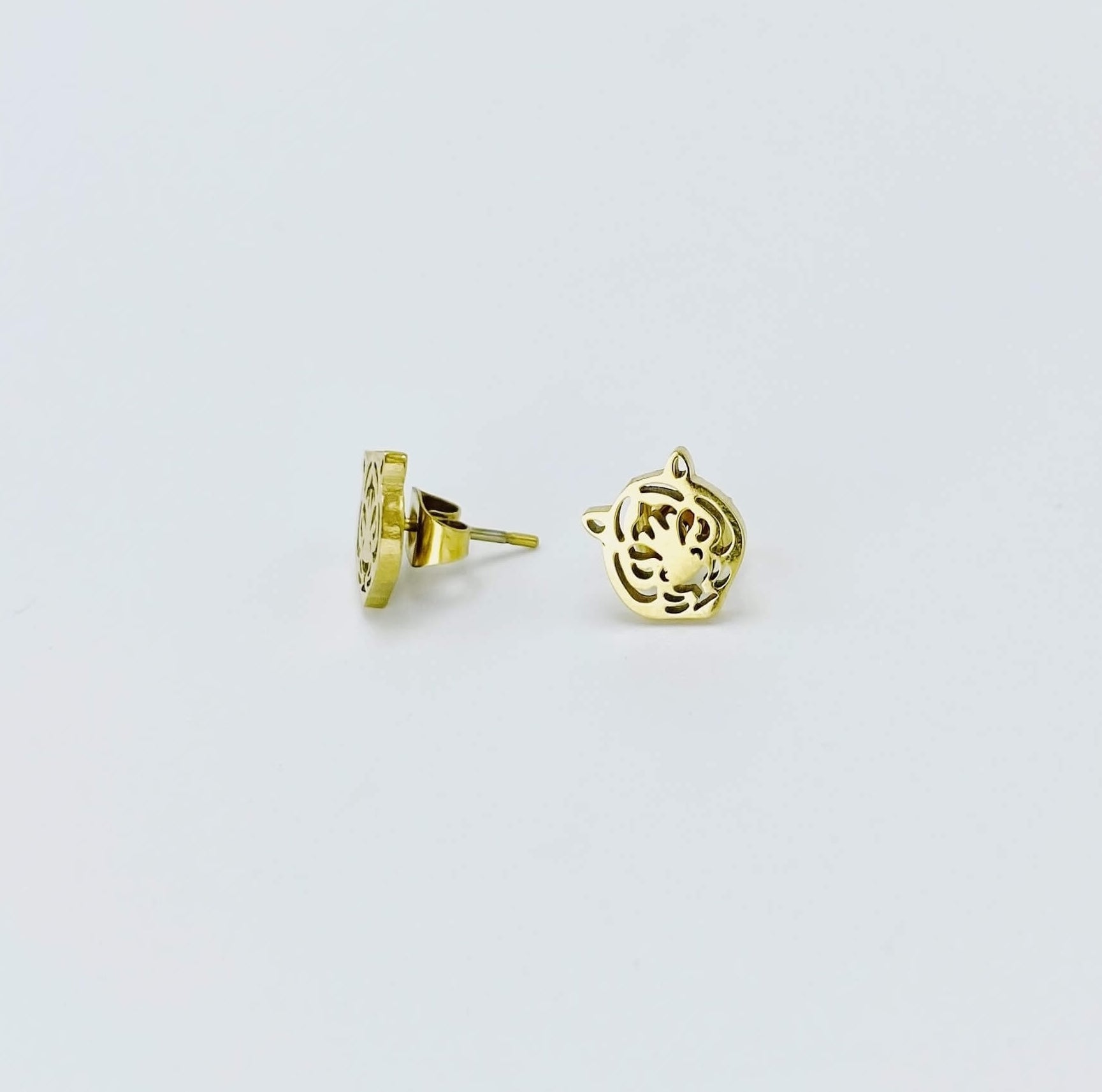 Metallic tiger stud earrings in a yellow gold hue made from stainless steel. 