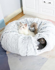Two cats playing with a plush gray donut tunnel.