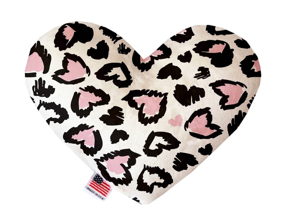 Heart shaped squeaker dog toy. White background with a pink and black leopard print heart pattern throughout. Made in USA label on bottom trim.