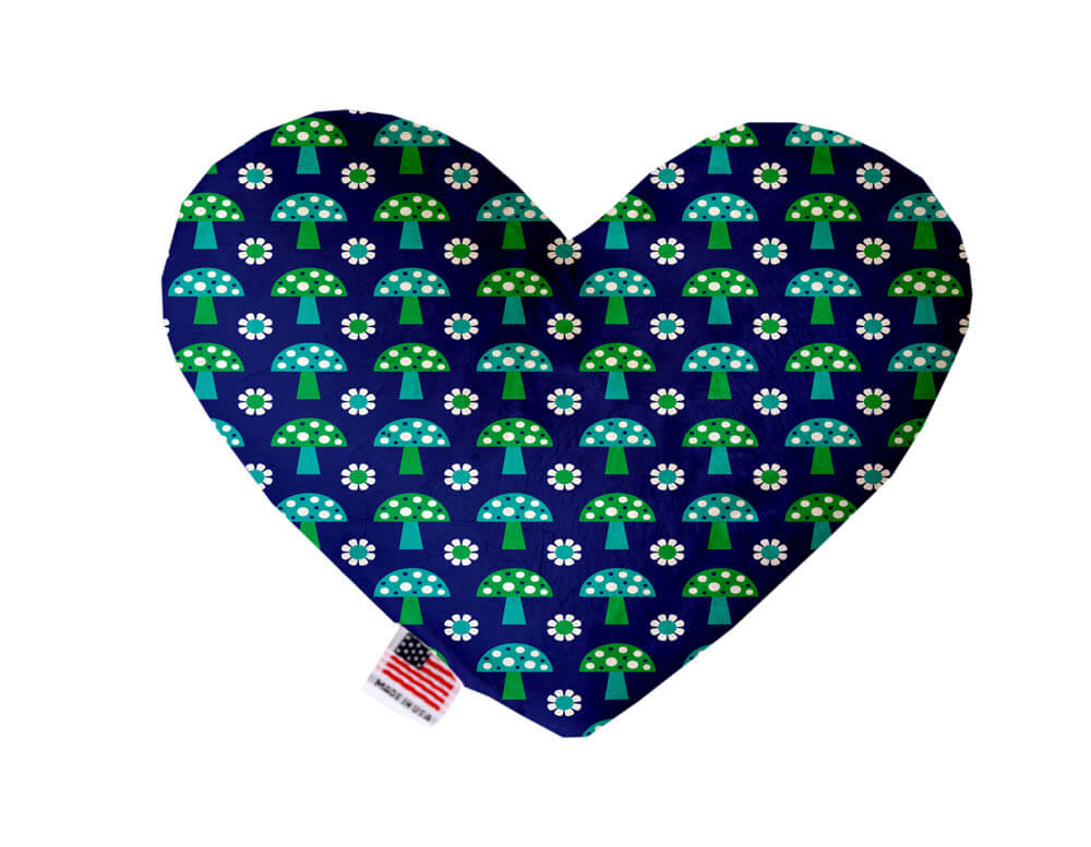 Heart shaped squeaker dog toy. Navy blue background with green and blue mushrooms and flowers printed throughout. Made in USA label on bottom trim.