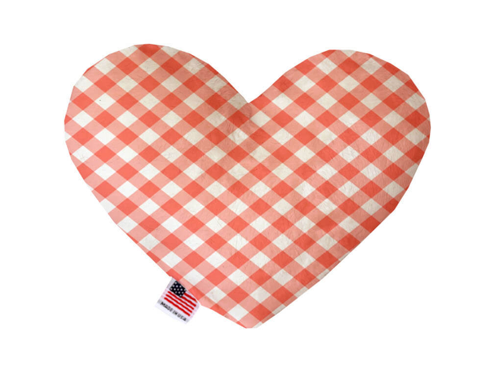 Heart shaped squeaker dog toy in an orange and white gingham print. Made in USA label on bottom trim.
