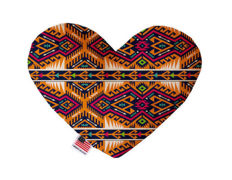 Heart shaped squeaker dog toy. Southwestern print. Main color is orange, with pink, turquoise, off-white and green accent colors. Made in USA label on bottom trim.