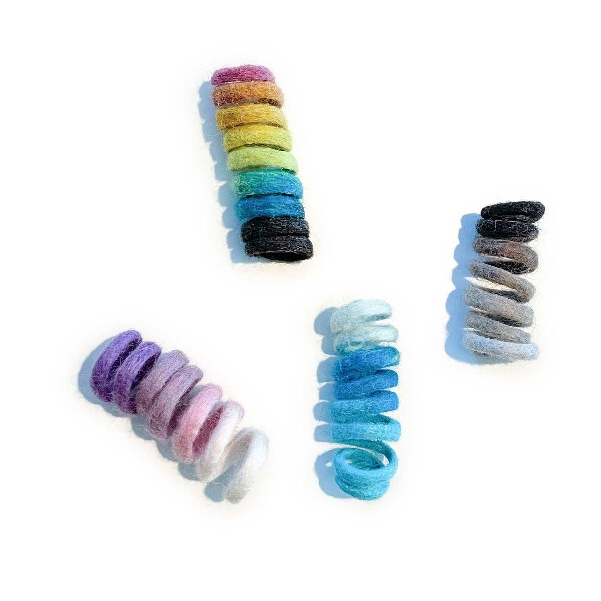 Organic wool spring cat toys in rainbow, purple, blue and neutral.