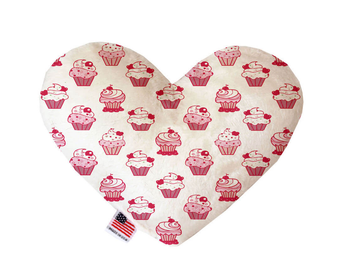 Heart shaped squeaker dog toy. White background with a pink cupcake print. Made in USA label on bottom trim.