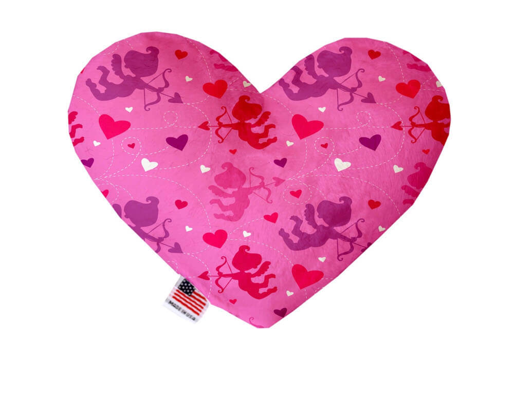 Heart shaped squeaker dog toy. Hot pink background with red, purple and white cupids and hearts printed throughout. Made in USA label on bottom trim.