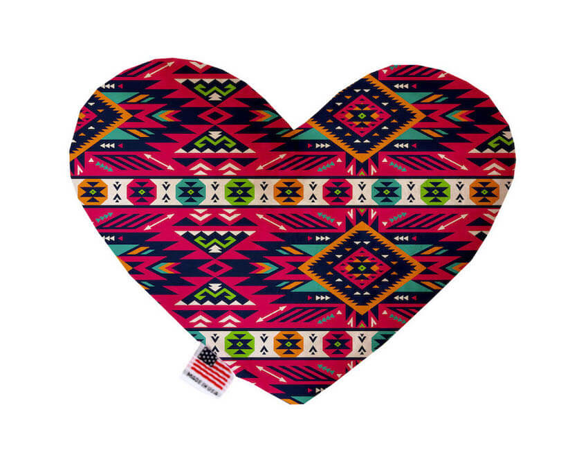 Heart shaped squeaker dog toy. Southwestern print. Main color is pink, with orange, turquoise, off-white and green accent colors. Made in USA label on bottom trim.