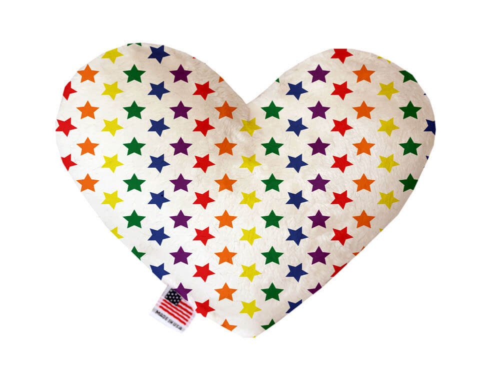 Heart shaped squeaker dog toy. White background with rainbow stars printed throughout. Made in USA label on bottom trim.
