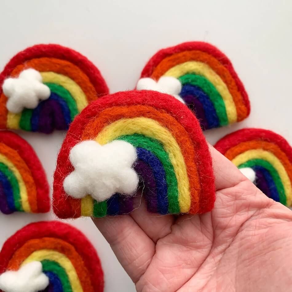 Rainbow wool cat toys with white cloud accents.